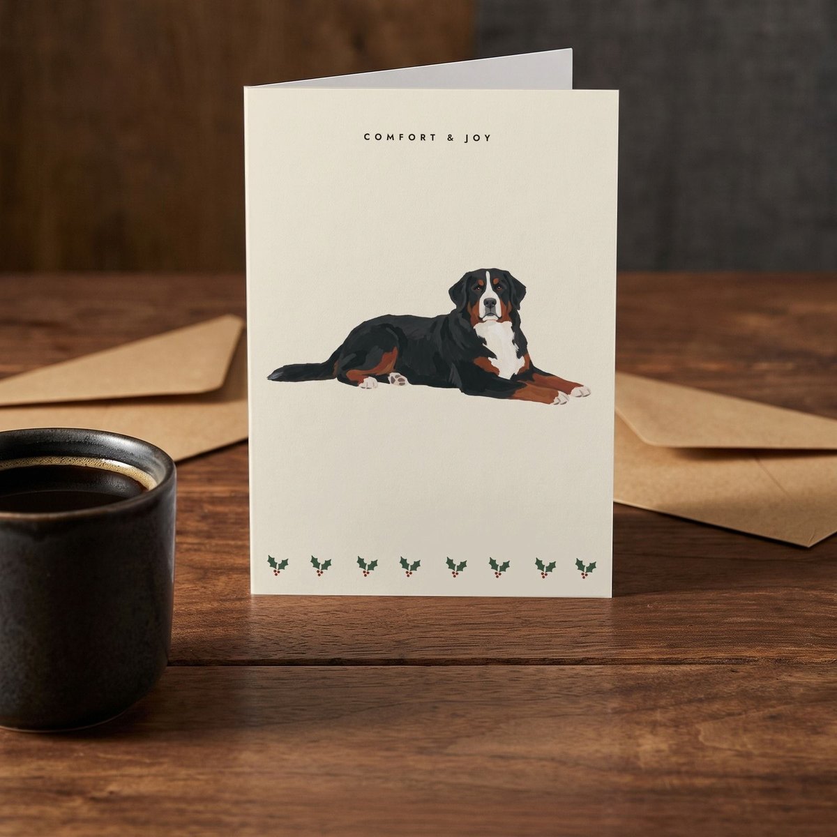 A folded card standing on a rustic wood table beside a mug of coffee